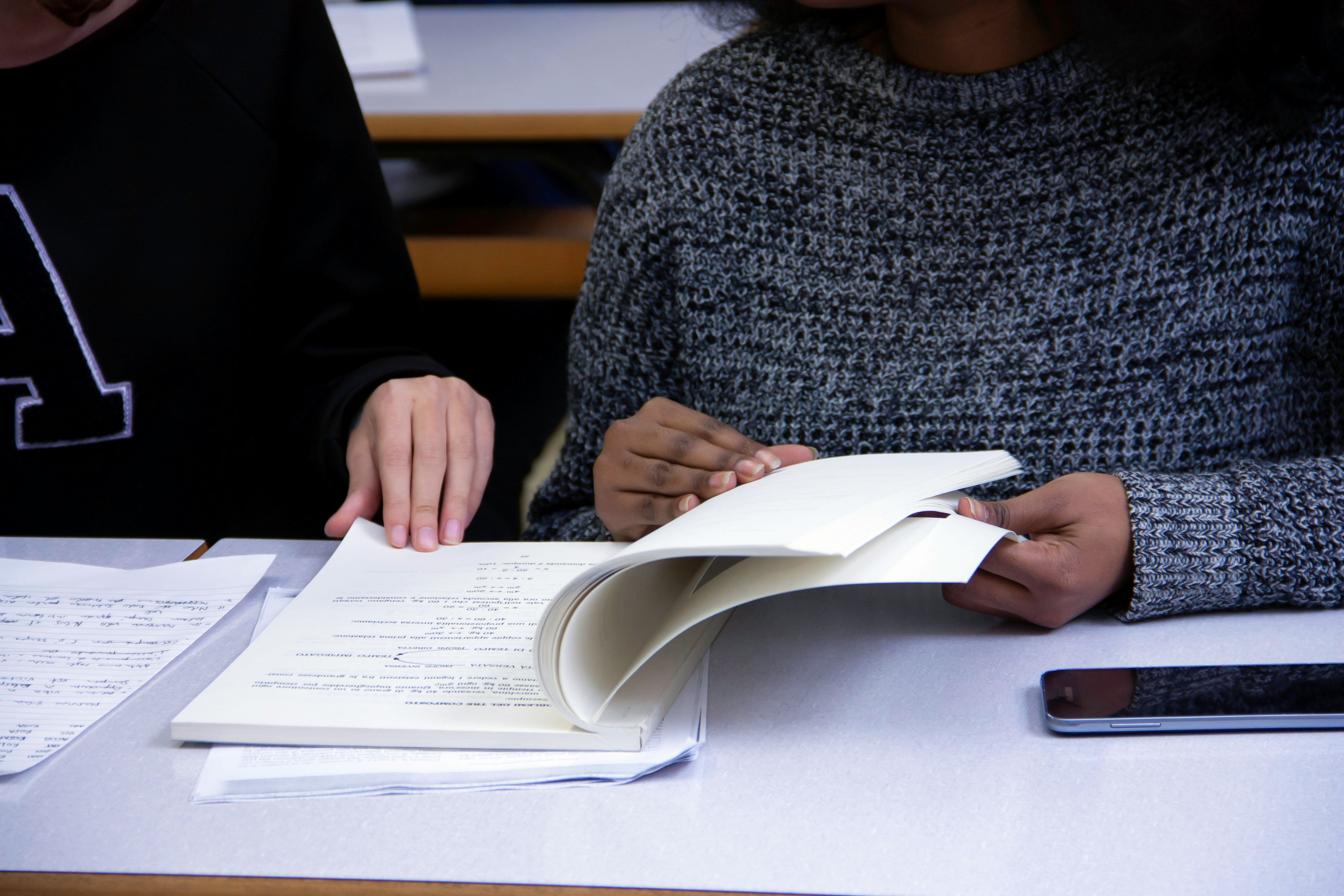 Two people reviewing a policy document at a desk - representing legal compliance and policy drafting work