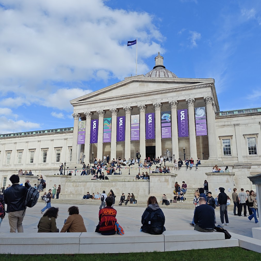UCL Portico building with UCL 200th anniversary banners and students gathered on the steps